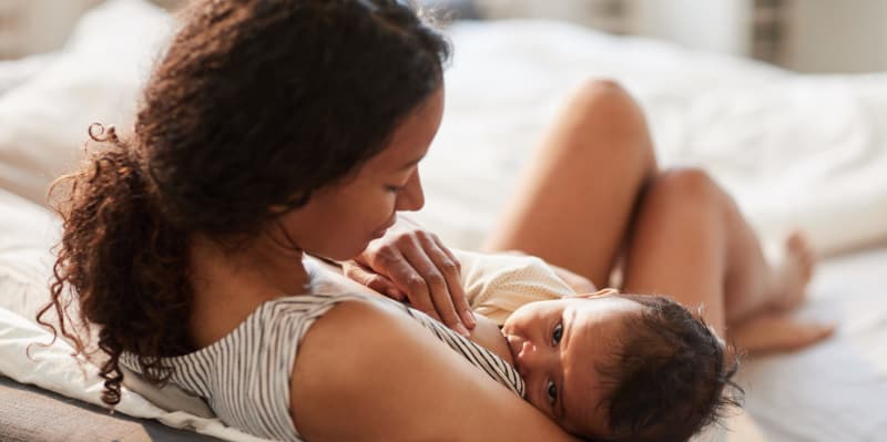 A young mother nurses her infant