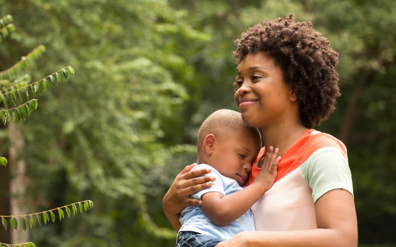 A Black mother holds her infant